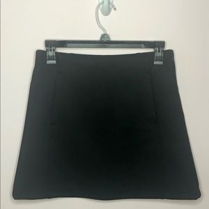 High-waisted mini skirt. Front pockets. Seam zip.